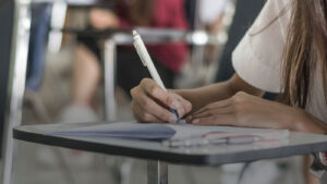 Student writing at desk